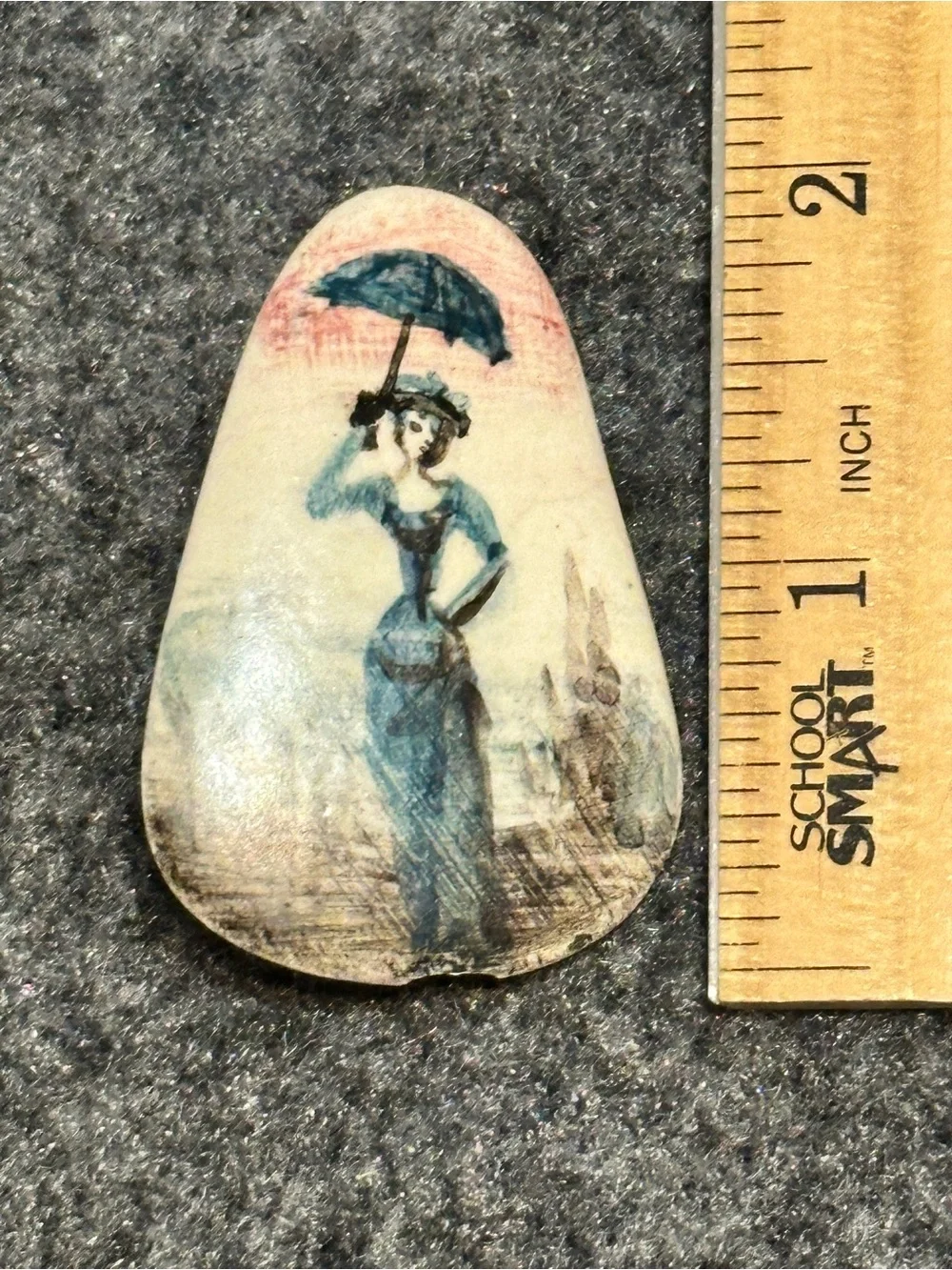 Small, hand-painted miniature artwork on a smooth stone or ceramic cabochon